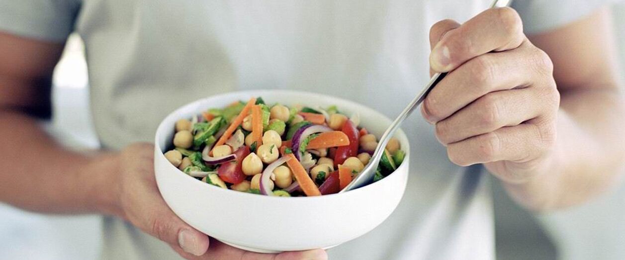 Мужчина ест продукты, полезные для потенции.